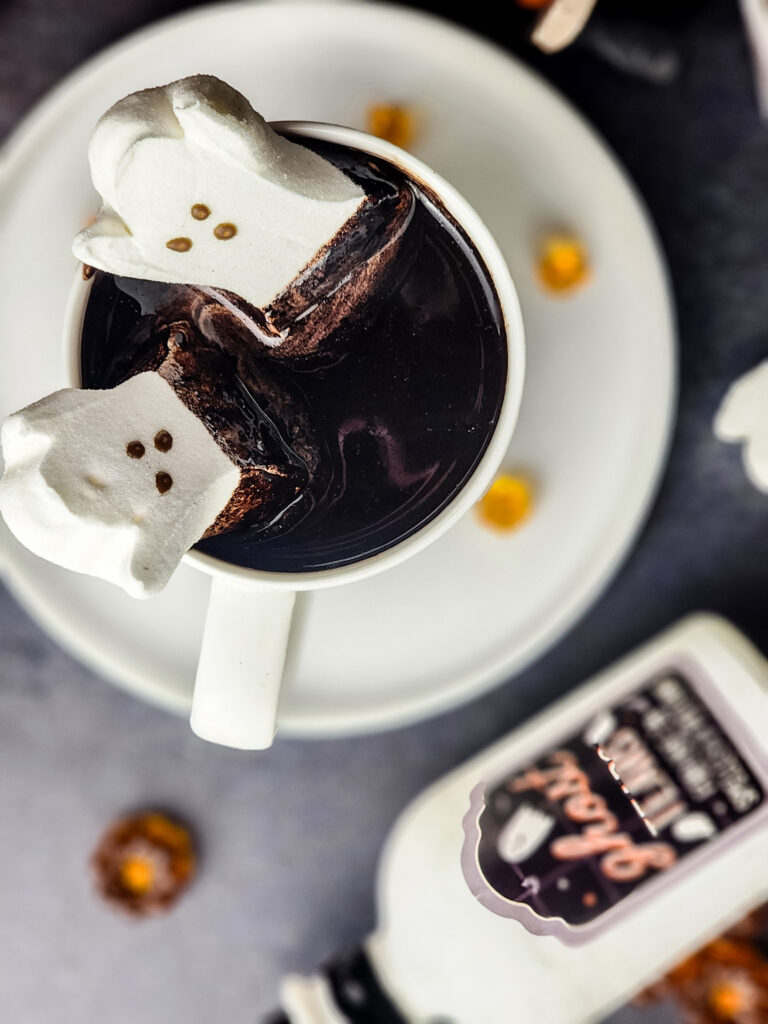 Halloween Black Hot Chocolate | When October rolls in and the nights get a little chillier, there’s nothing better than curling up with a mug of decadent hot cocoa—especially when it’s dressed for Halloween! This year, I’m brewing up something extra special: Black Hot Cocoa. Made with rich black cocoa powder, creamy caramel sauce, and topped with the cutest Ghost Peeps, this drink is as hauntingly delicious as it is festive.
