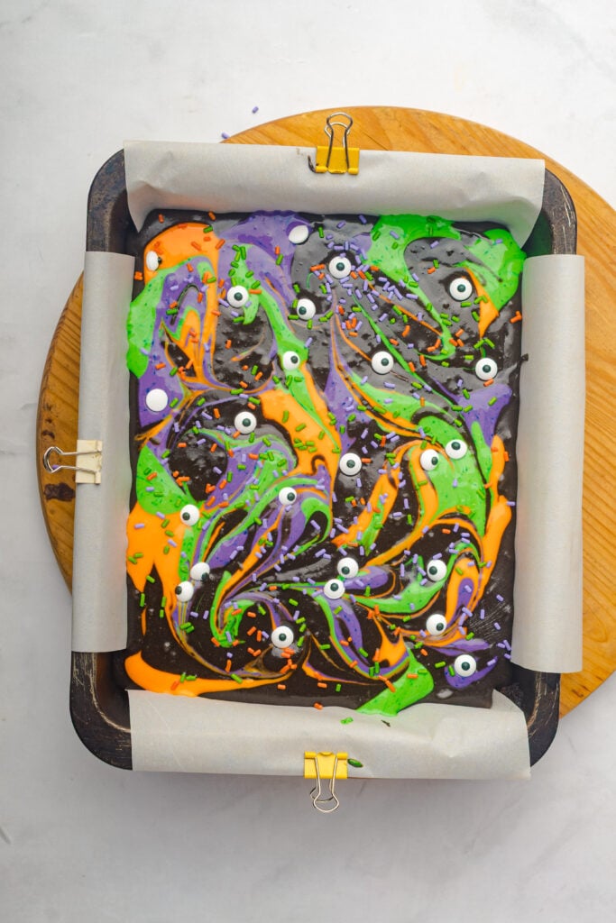 Halloween Cream Cheese Swirl Brownies | These brownies are simple to put together but make a big impression with their colorful cream cheese swirls and deep chocolate flavor. Using real dark chocolate and a touch of cocoa gives them a fudgy texture, while the cream cheese adds a creamy contrast in every bite.