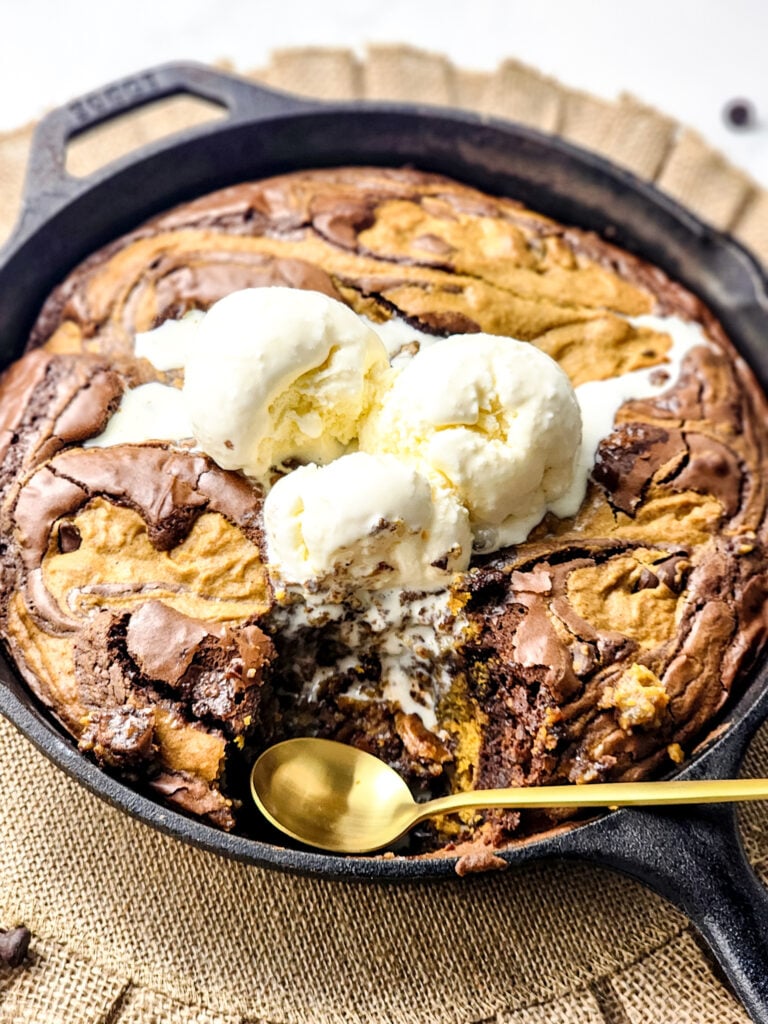 Pumpkin Brookie Skillet | Fudgy brownies meet pumpkin spice in this gooey skillet brookie—swirled with chocolate chips and bursting with cozy fall flavor!