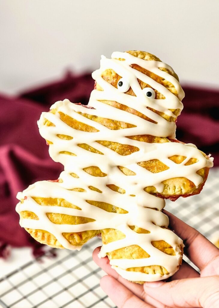 These Halloween Mummy Pop Tarts are spooky, easy, and delicious—flaky pastry, sweet jam, icing, and edible eyes!