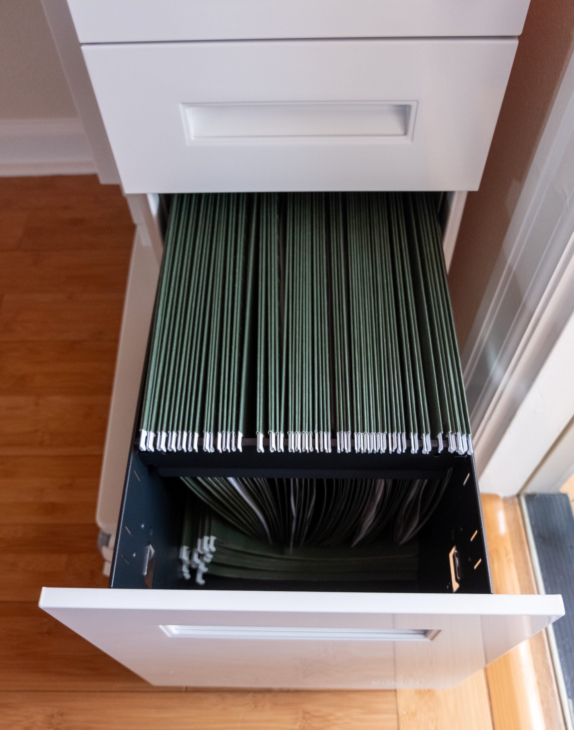 Gift Guide for People Who Practically Live at Their Desk: UPLIFT Accessories Review, featuring Engage Stool, Pop-up Power Grommet, Hook and Loop Wire Wraps, and the 3-Drawer Narrow Square File Cabinet.