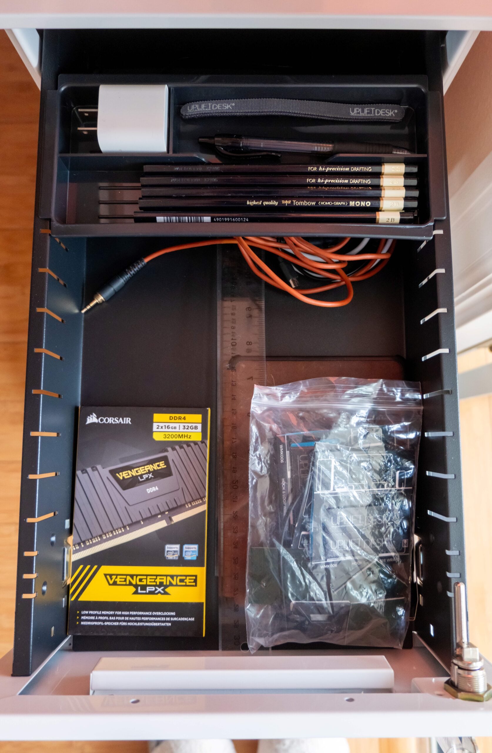 Gift Guide for People Who Practically Live at Their Desk: UPLIFT Accessories Review, featuring Engage Stool, Pop-up Power Grommet, Hook and Loop Wire Wraps, and the 3-Drawer Narrow Square File Cabinet.