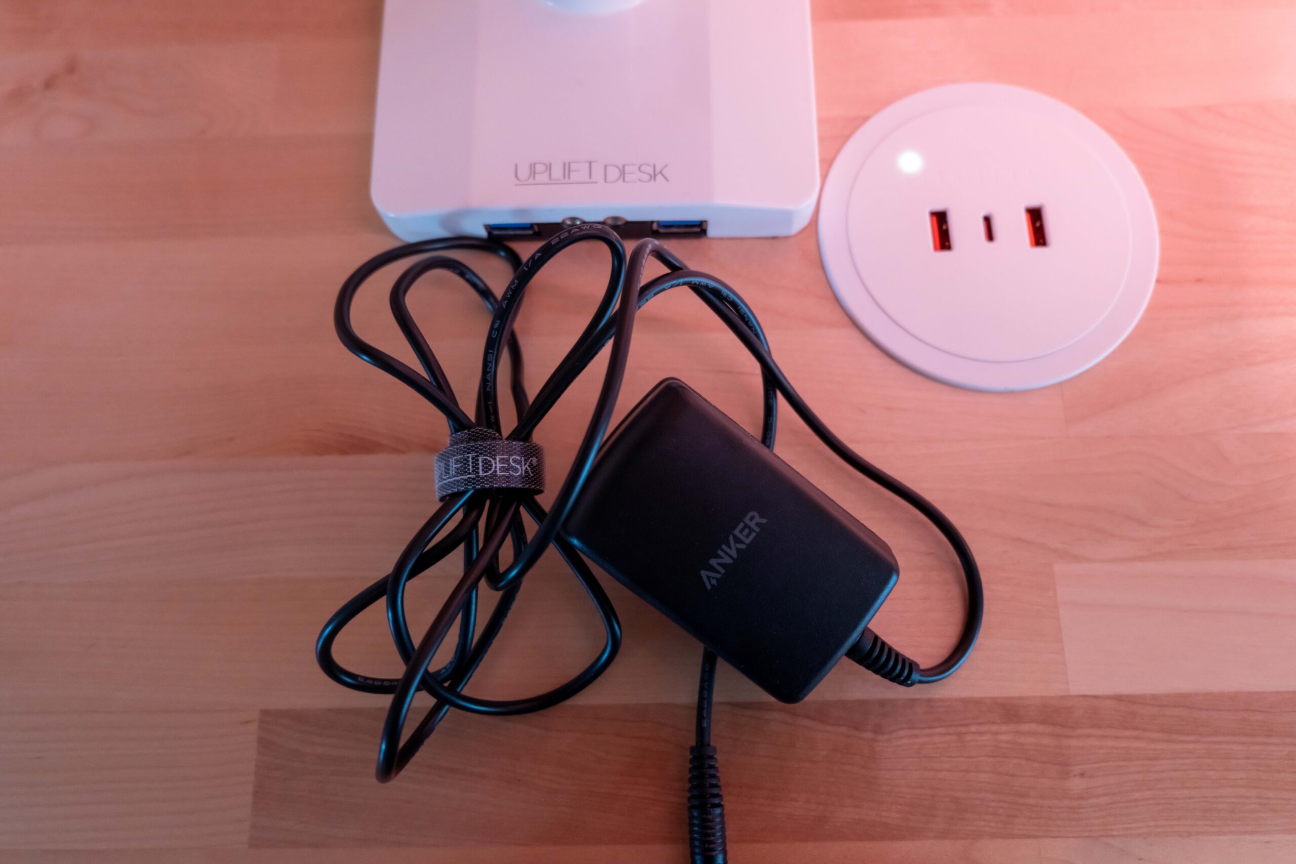 Gift Guide for People Who Practically Live at Their Desk: UPLIFT Accessories Review, featuring Engage Stool, Pop-up Power Grommet, Hook and Loop Wire Wraps, and the 3-Drawer Narrow Square File Cabinet.