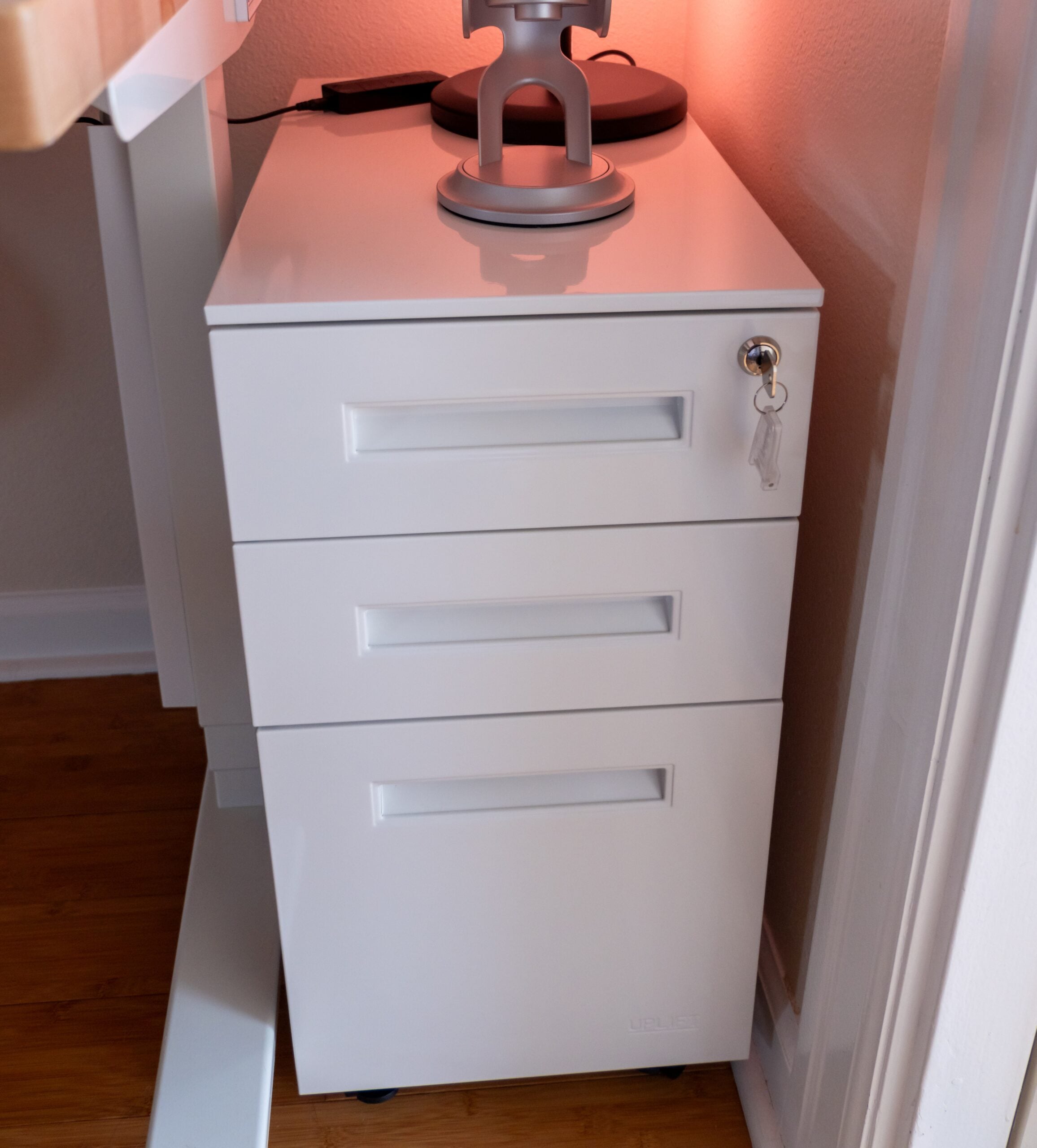 Gift Guide for People Who Practically Live at Their Desk: UPLIFT Accessories Review, featuring Engage Stool, Pop-up Power Grommet, Hook and Loop Wire Wraps, and the 3-Drawer Narrow Square File Cabinet.